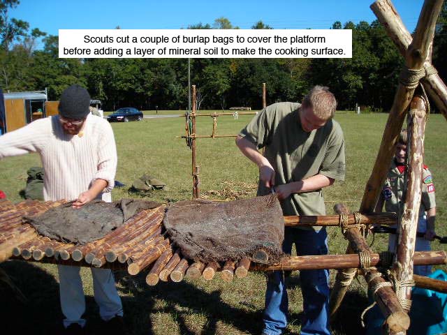 Scouts cut a couple of burlap bags before adding a layer of mineral soil to make the cooking surface.