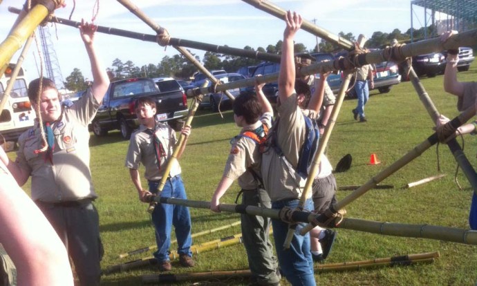 Scouts carefully lift the structure and rotatie it 180° to lash the other side.
