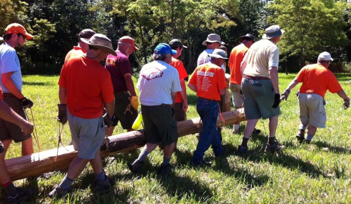 Carrying a heavy spar in pairs, along each side.